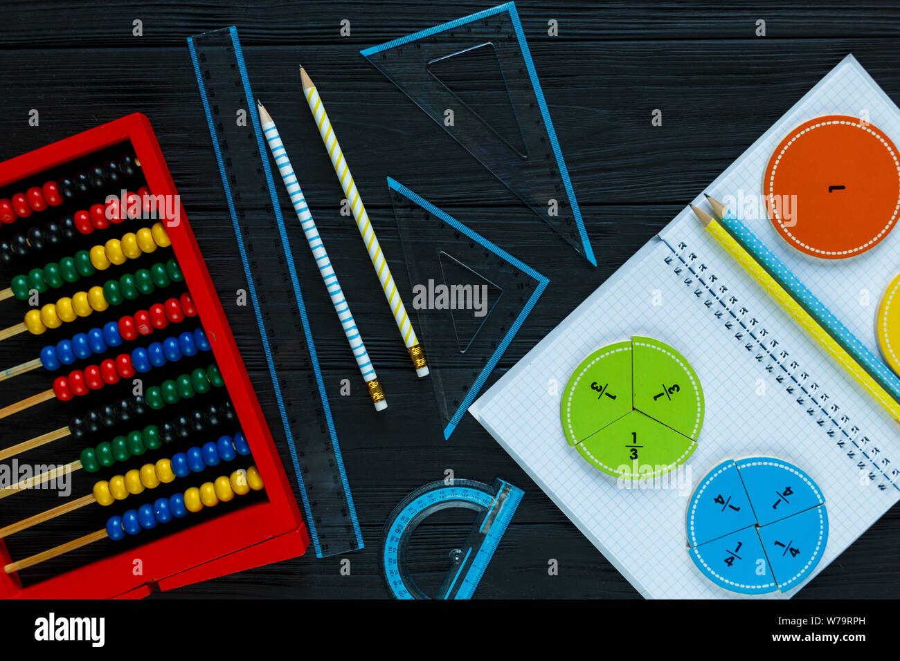 Creative Сolorful math fractions on dark background. Interesting funny math for kids. Education, back to school concept. Geometry and mathematics Stock Photo