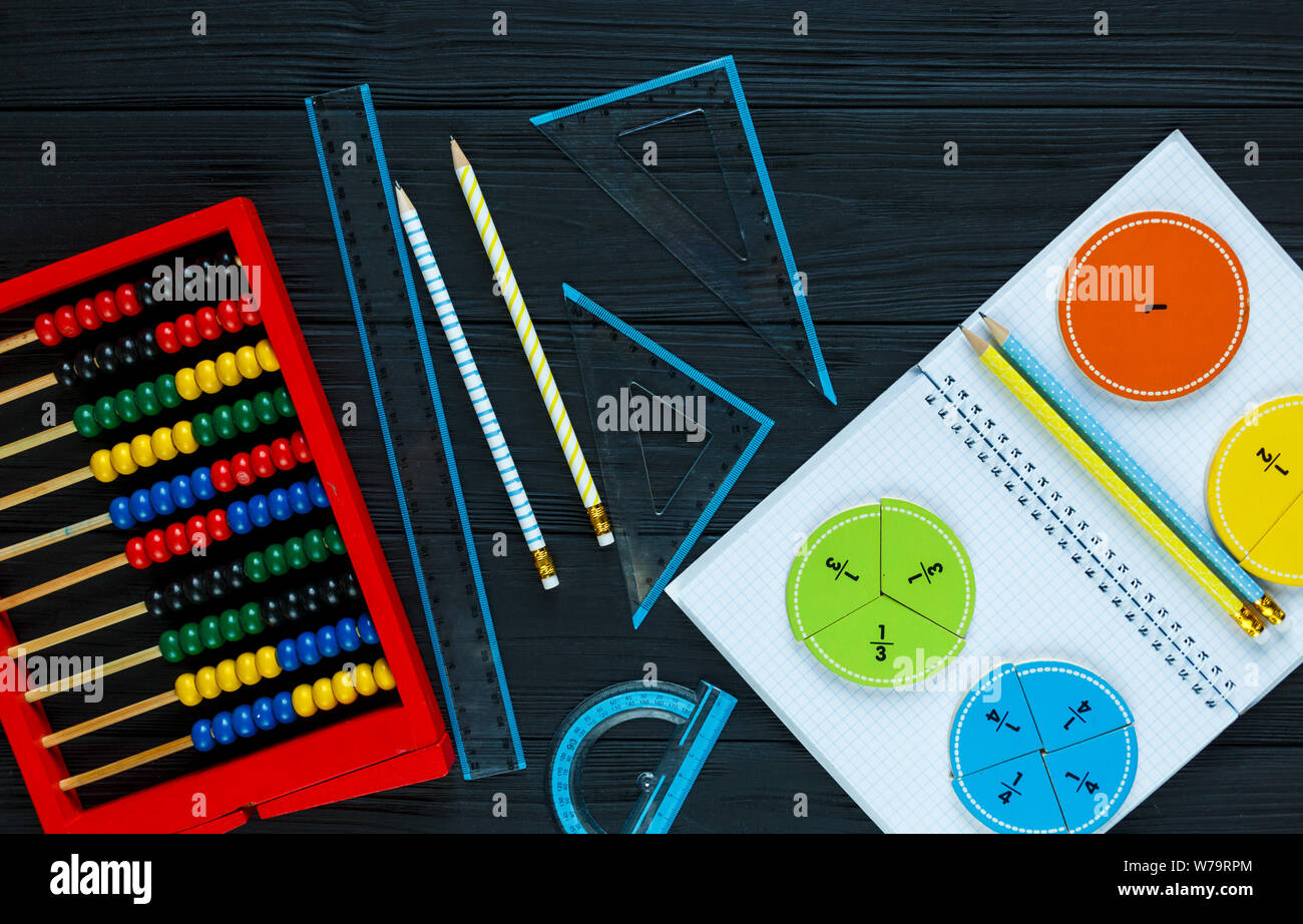 Creative Сolorful math fractions on dark background. Interesting funny math for kids. Education, back to school concept. Geometry and mathematics Stock Photo