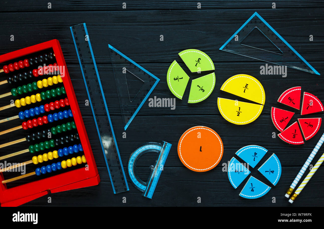 Creative Сolorful math fractions on dark background. Interesting funny math for kids. Education, back to school concept. Geometry and mathematics Stock Photo