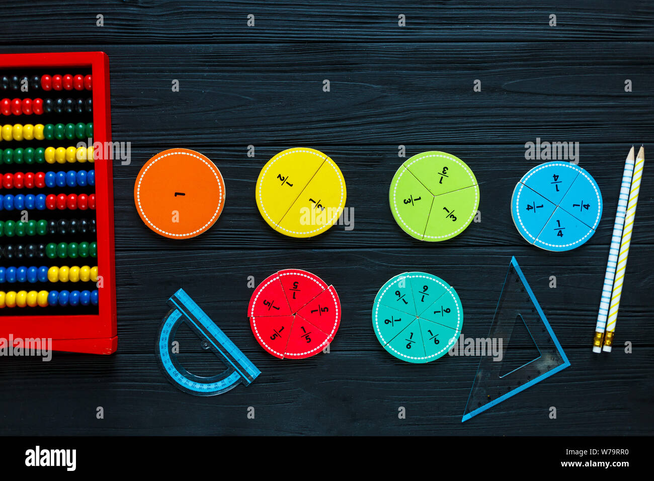 Creative Сolorful math fractions on dark background. Interesting funny math for kids. Education, back to school concept. Geometry and mathematics Stock Photo