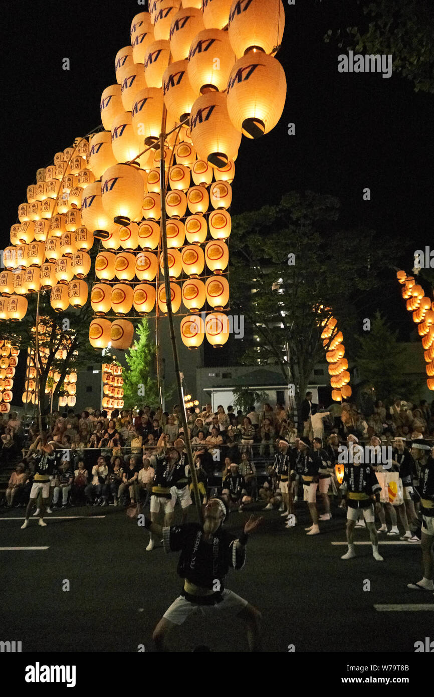 Crowds watch as traditional candlelit Japanese lanterns are raised on bamboo poles and paraded at the Akita Kanto Matsuri Festival in 2016. Stock Photo