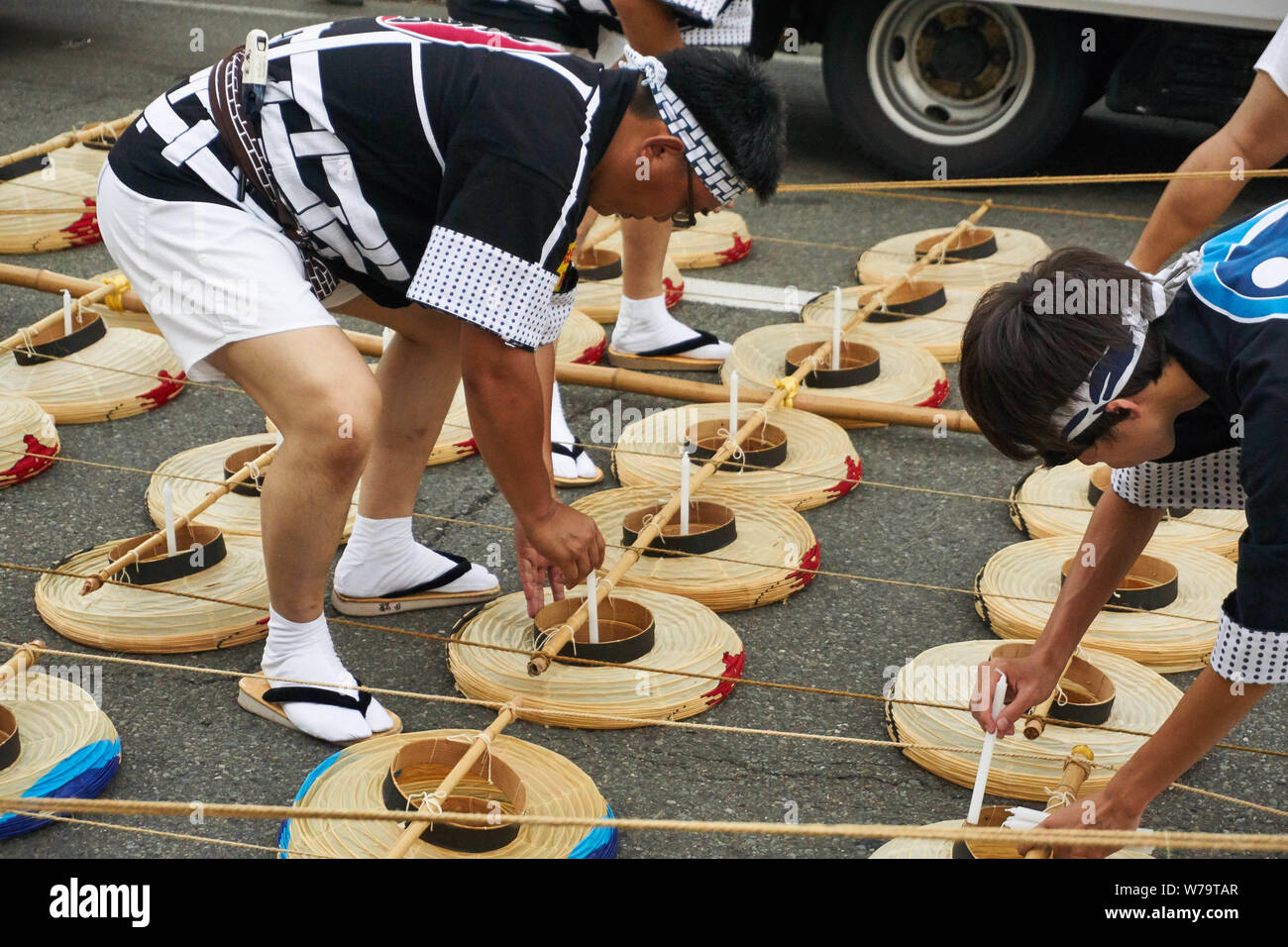 Japanese men add candles to the traditional Japanese lanterns at the Akita Kanto Matsuri in 2016. Stock Photo