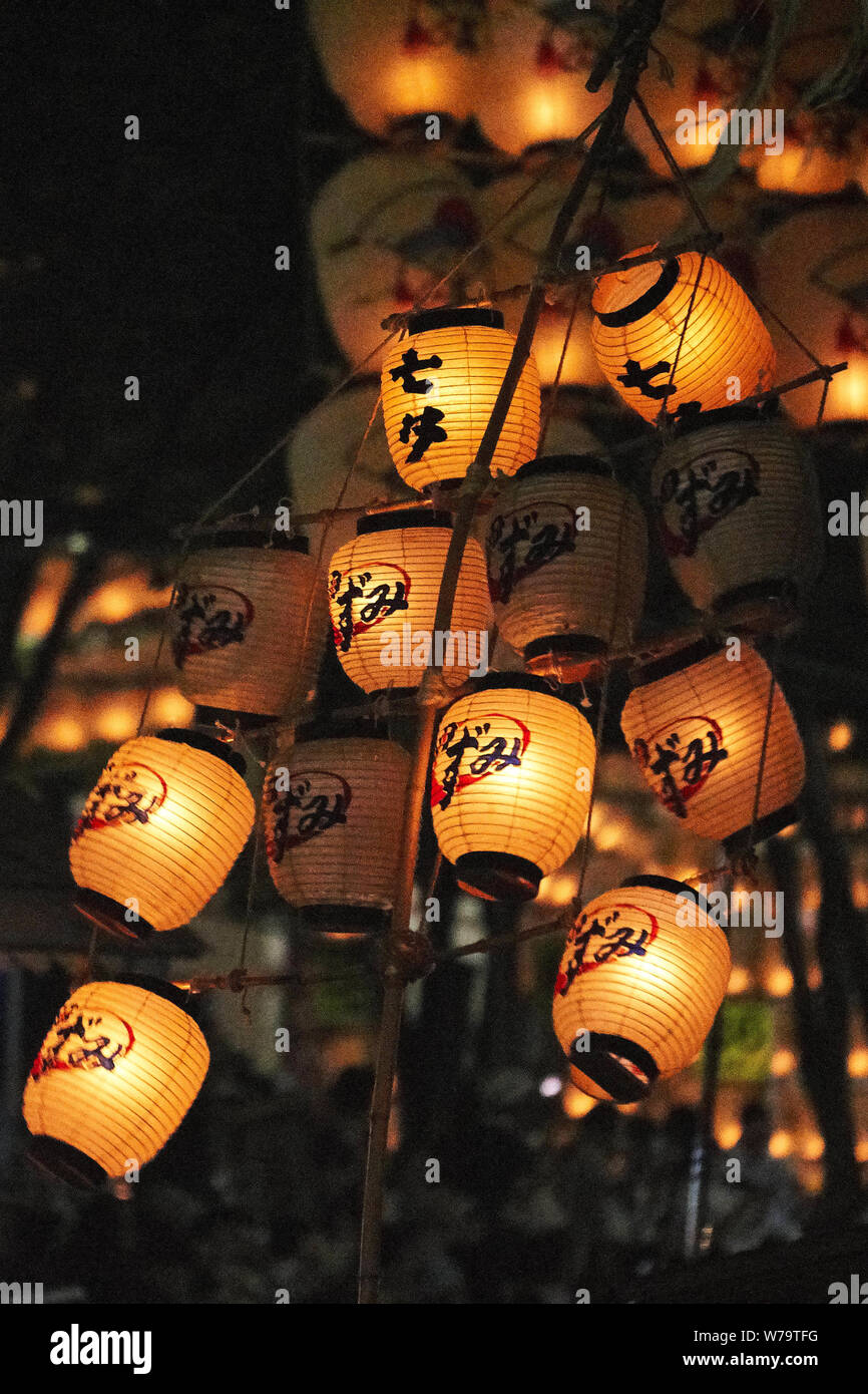 Traditional Japanese lanterns swing around on bamboo poles during the Akita Kanto Matsuri Festival in 2016. Stock Photo
