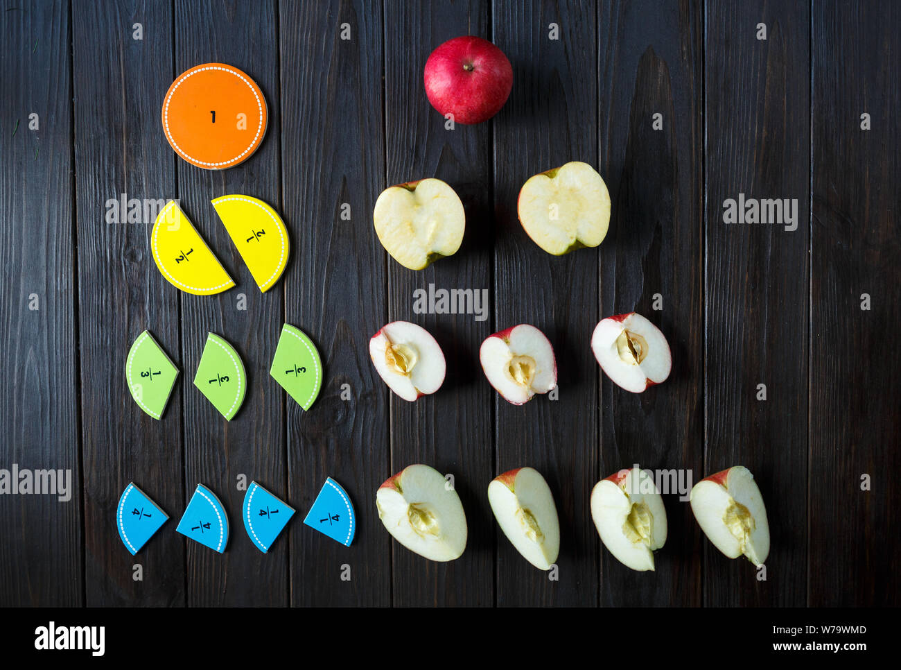 colorful math fractions and apples as a sample on brown wooden background or table. interesting math for kids. Education, back to school concept. Stock Photo