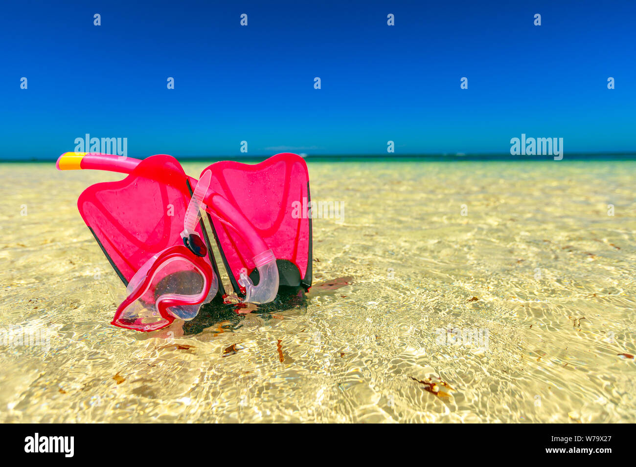 Summer equipment for snorkeling. Scuba mask with fins in pink color on the water. Hangover Bay in Nambung National Park, Western Australia. Blue sky Stock Photo