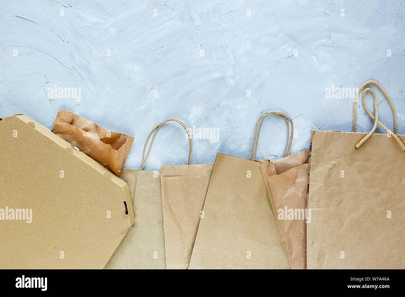 Flat lay of paper wastes as bags, boxes ready for recycling on gray