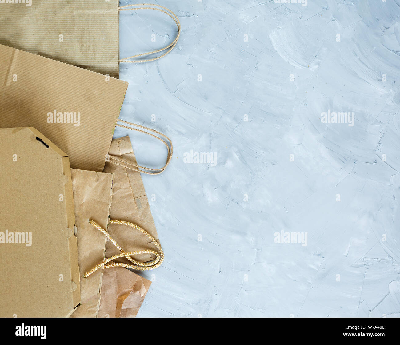 Flat lay of paper wastes as bags, boxes ready for recycling on gray