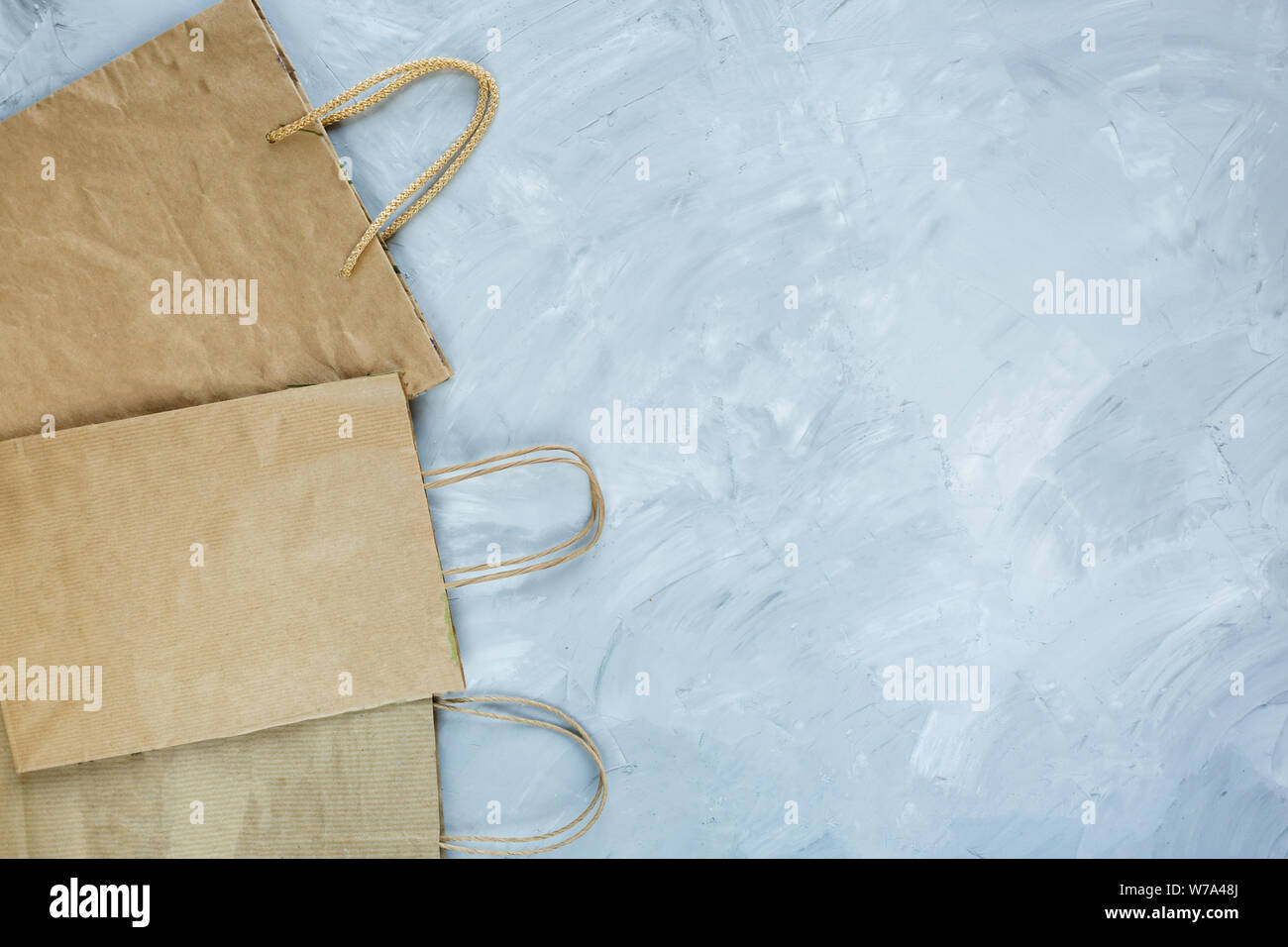 Flat lay of paper wastes as bags, boxes ready for recycling on gray