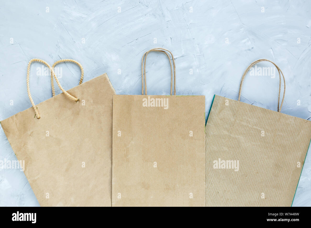Flat lay of paper wastes as bags, boxes ready for recycling on gray