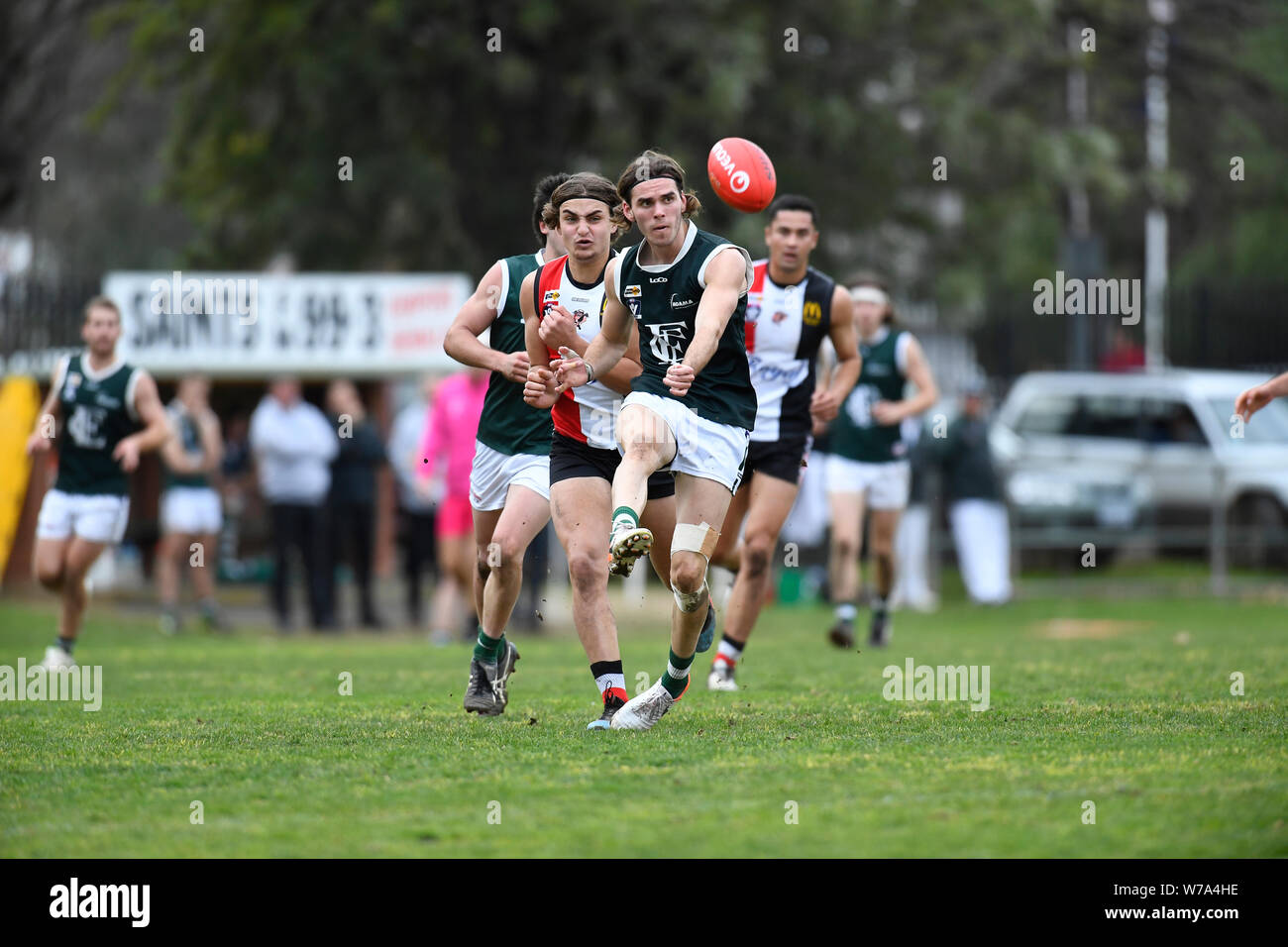 Murray Bomber Mitch Kemp fires a shot away whilst on attack against the Benalla Saints at Benalla's Footy Oval Stock Photo