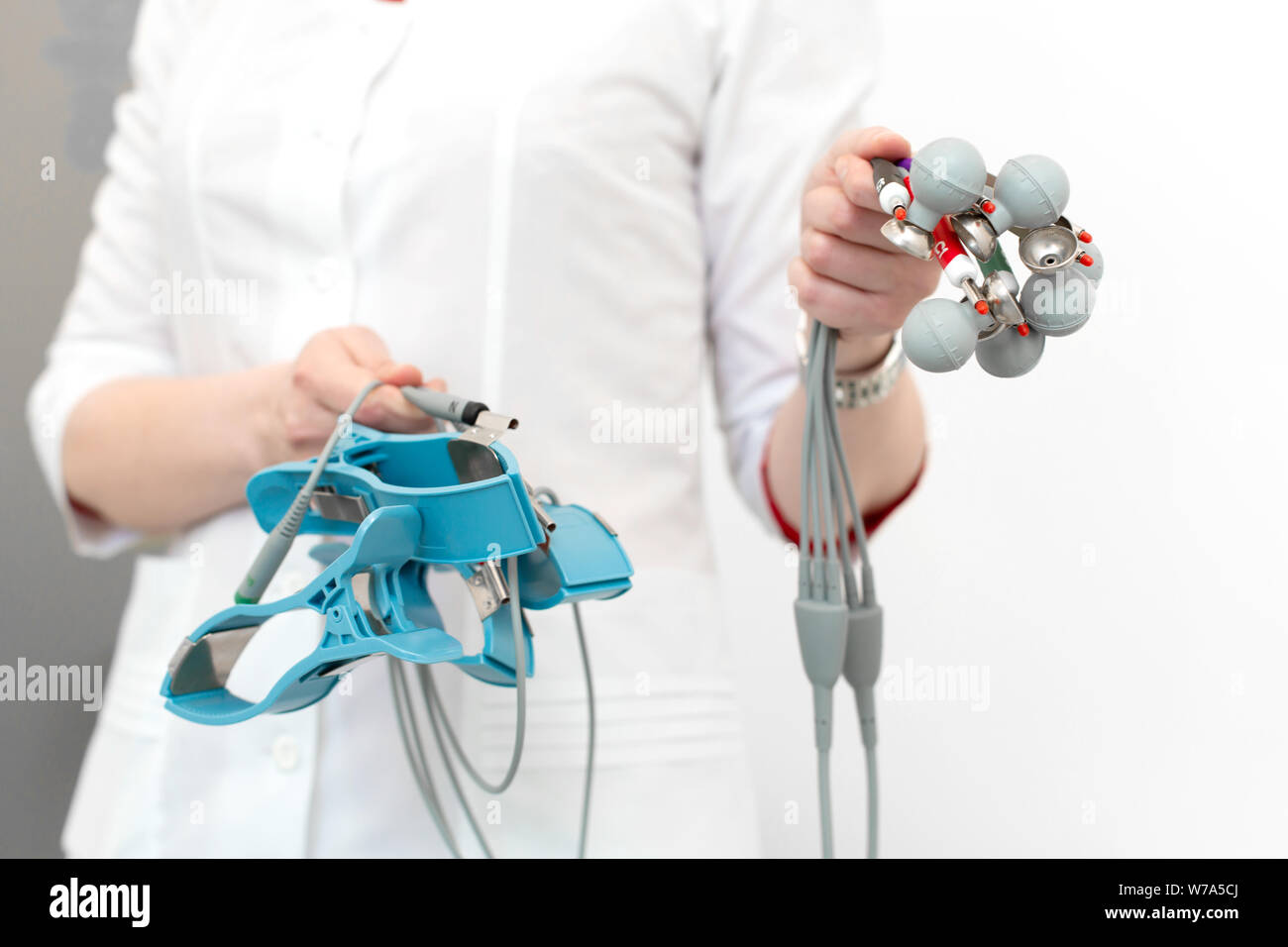 The cardiologist holds the electrocardiograph sensors in his hands ...