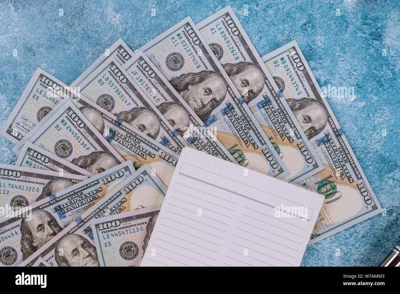 Notebook and dollars on blue marble background. Stock Photo