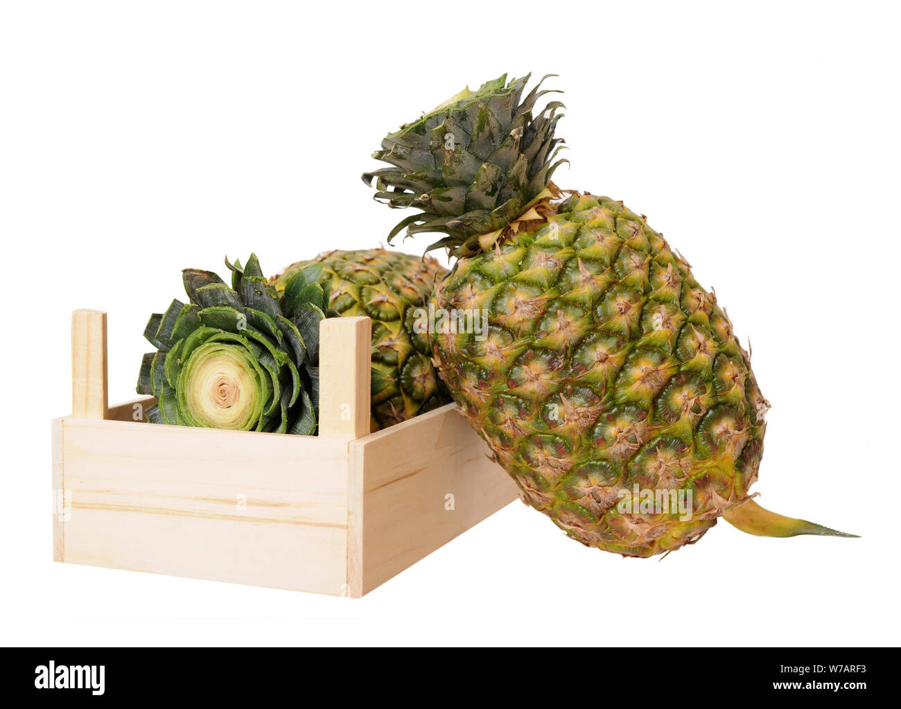 two ripe pineapples in crate isolated on white background Stock Photo