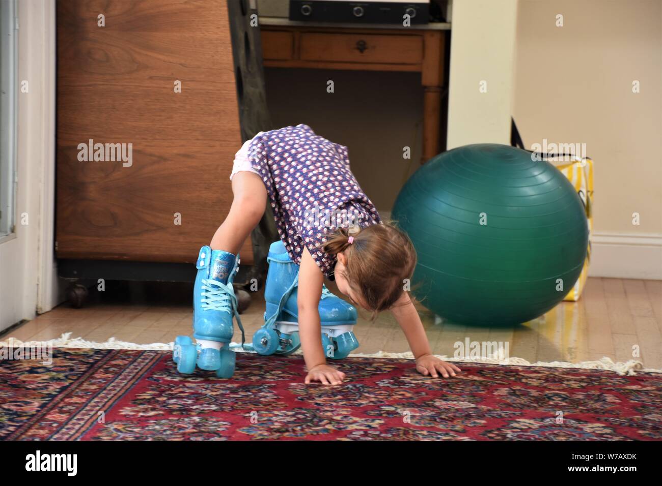 a real 5 five year old girl trying to use plastic blue roller skates