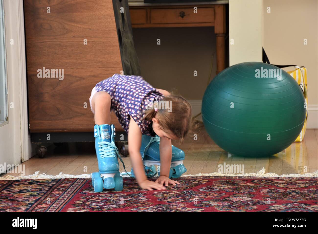 a real 5 five year old girl trying to use plastic blue roller skates