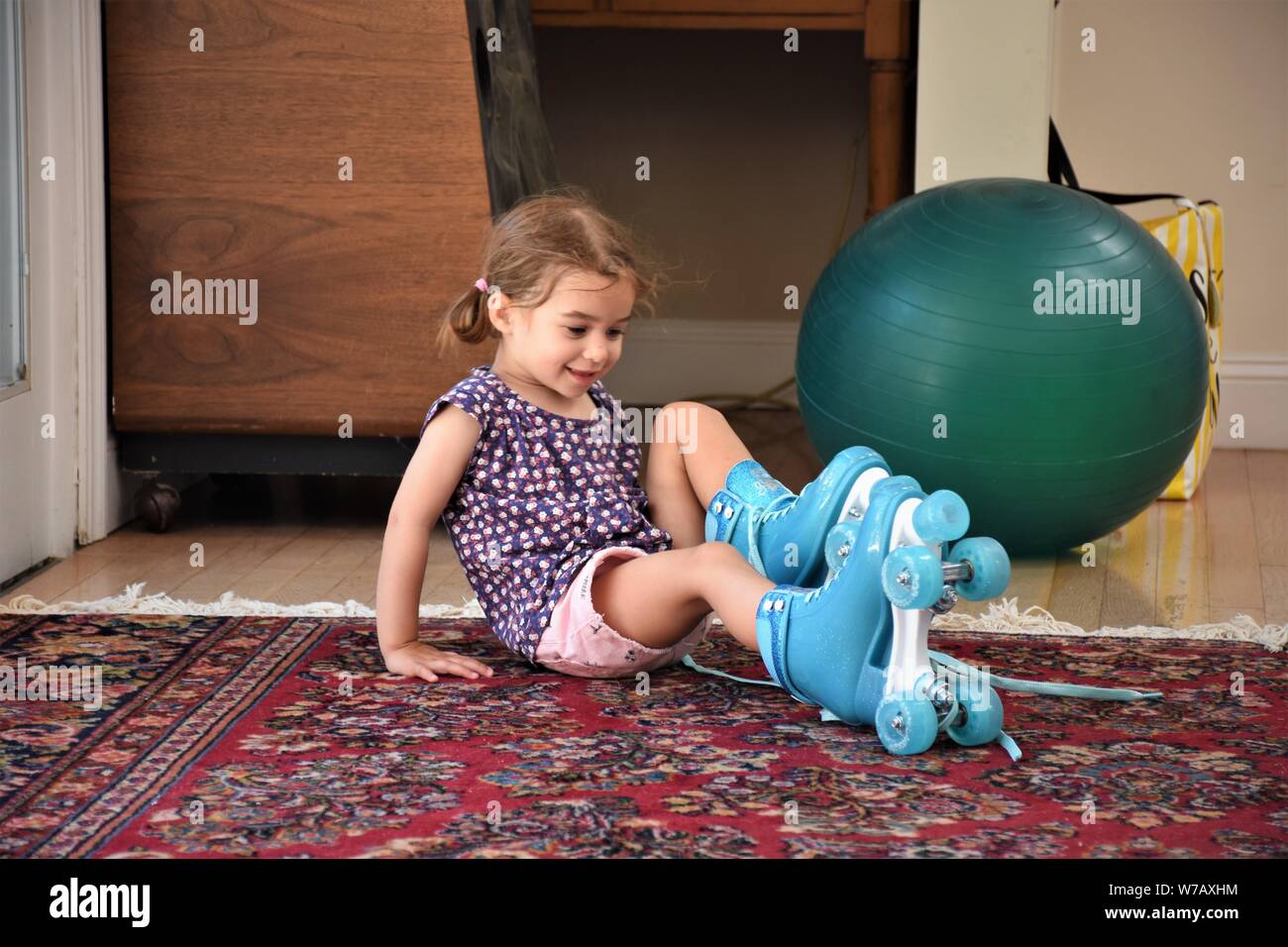 a real 5 five year old girl trying to use plastic blue roller skates