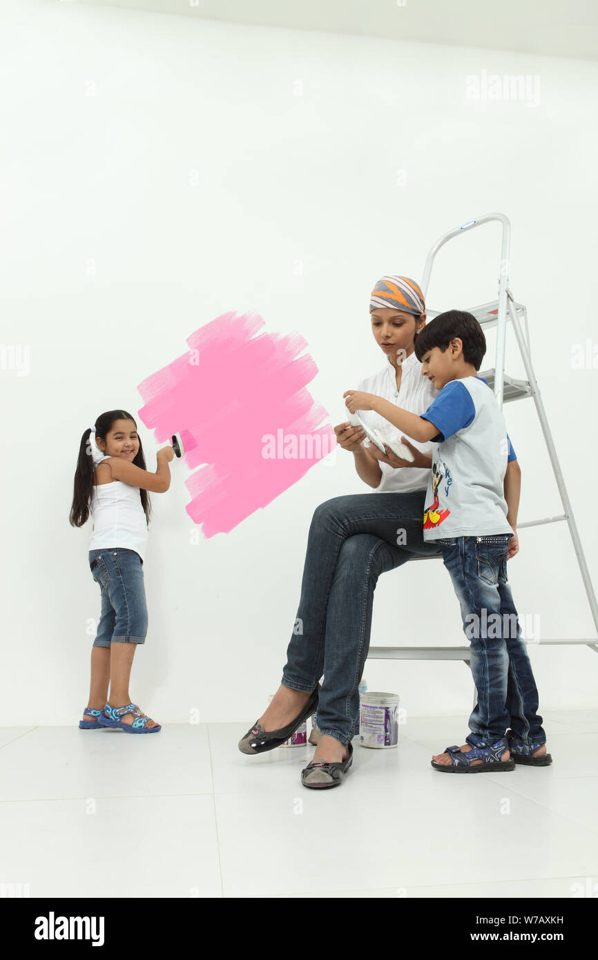 Woman with her children choosing color sample for room Stock Photo - Alamy