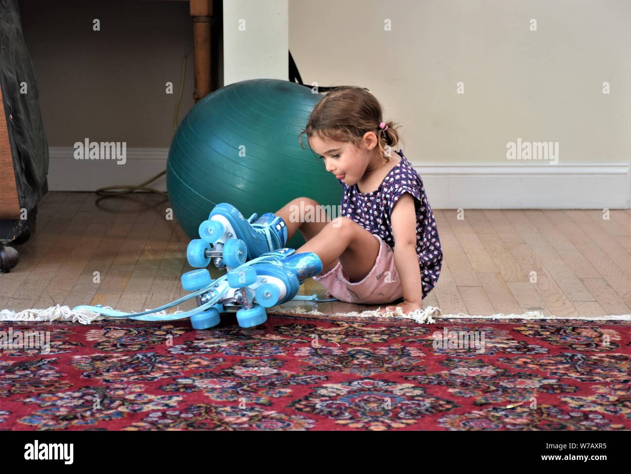a real 5 five year old girl trying to use plastic blue roller skates