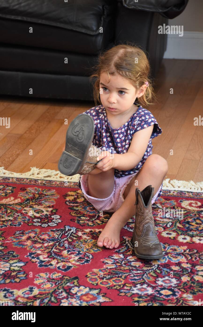 5 year old putting on real cowboy cowgirl boots at home in California ...