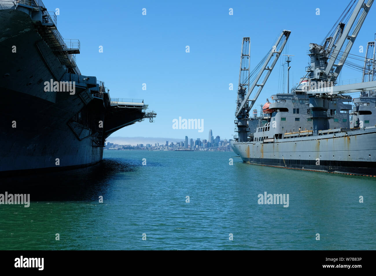The downtown San Francisco skyline from across the San Francisco Bay in Alameda, California seen between the USS Hornet and SS Grand Canyon State. Stock Photo