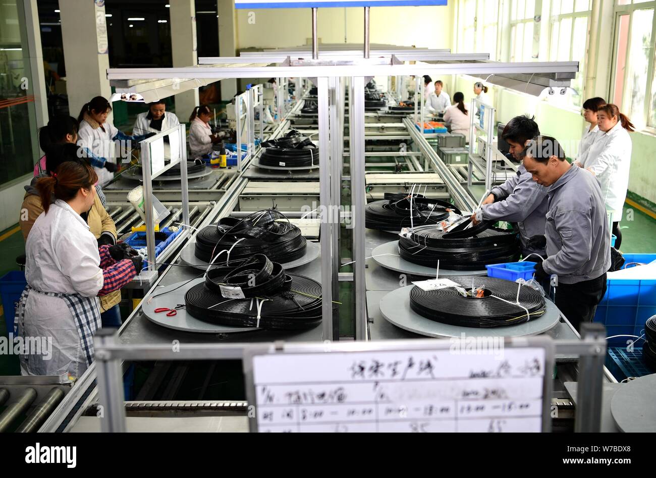 --FILE--Chinese workers produce cables on the cable assembly line at a factory of Nantong Zhongyao Draka Elevator Products Co., Ltd. in Nantong city, Stock Photo