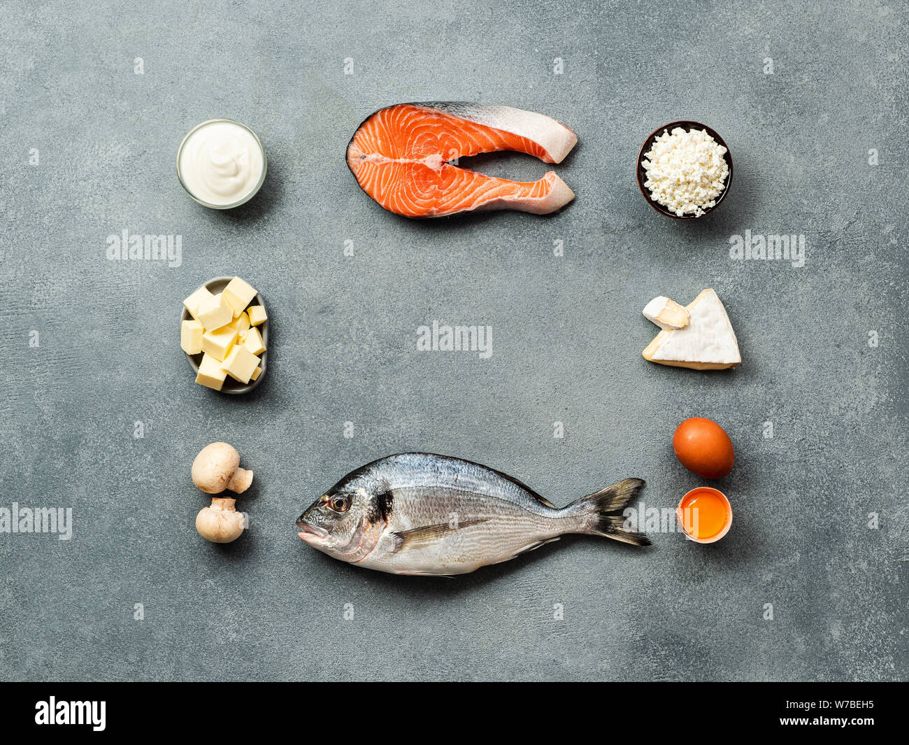 Vaitamin D sources concept with copy space in center. Fish, salmon, dairy products, eggs, mushrooms on gray stone background. Top view or flat lay. Stock Photo