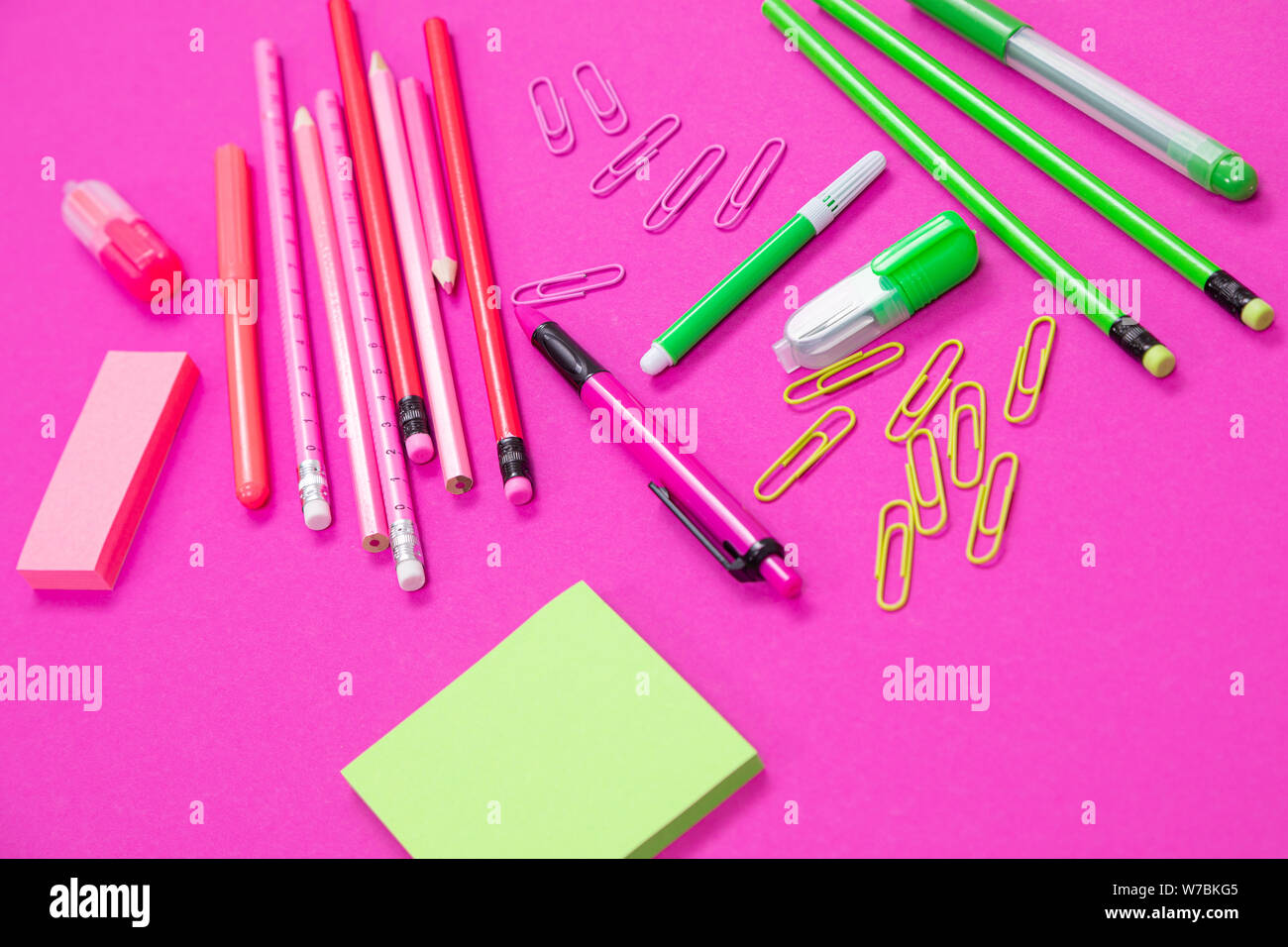 Group of pink and bright green office incidentals on pink background isolated Stock Photo