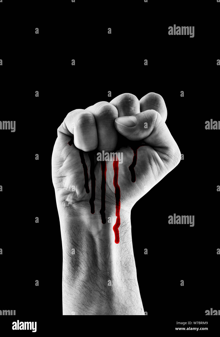 Raised hand showing fist with red blood isolated on black background Stock Photo