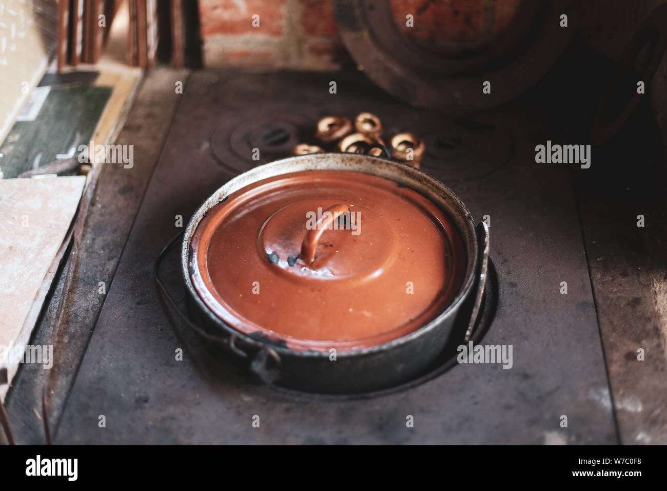 Cast iron pot on wooden stove with fresh mushrooms in the countryside Stock Photo