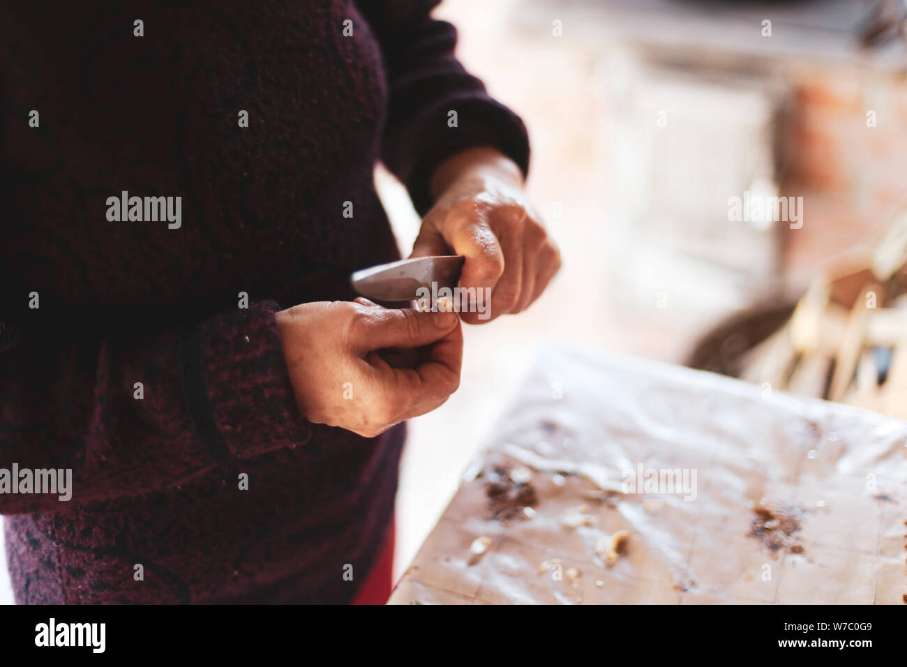 Details with the hands of an old woman peeling garlic for cooking Stock ...