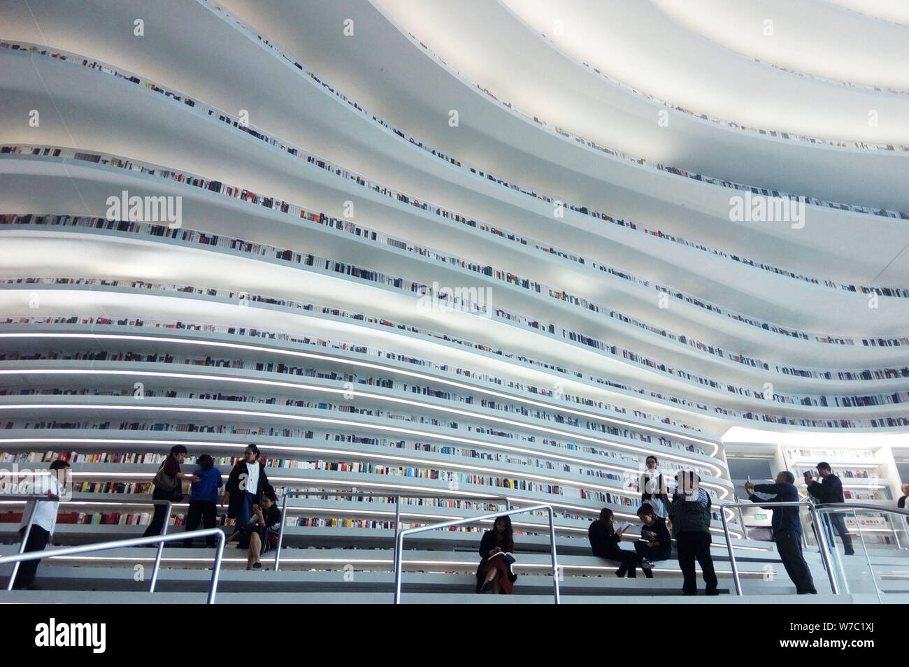 --FILE--People visit the Tianjin Binhai Library which displays a large ...