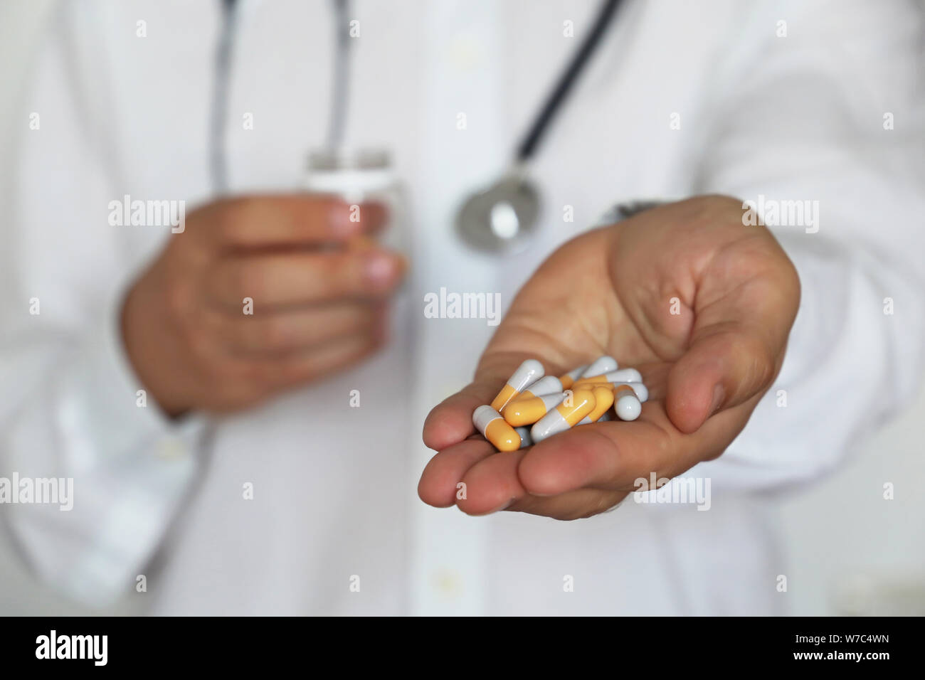 Doctor giving pills, physician holding in palm of hand medication in capsules. Concept of dose of drugs, vitamins, medical exam, pharmacy, flu Stock Photo