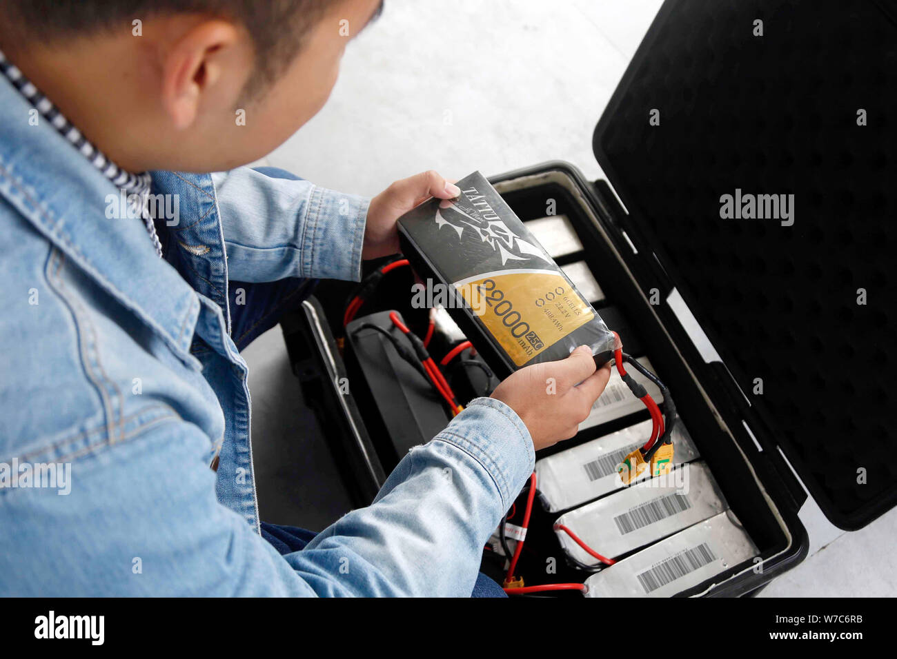 A Chinese enthusiast checks the batteries for drone, or UAV (unmanned aerial vehicle), at the