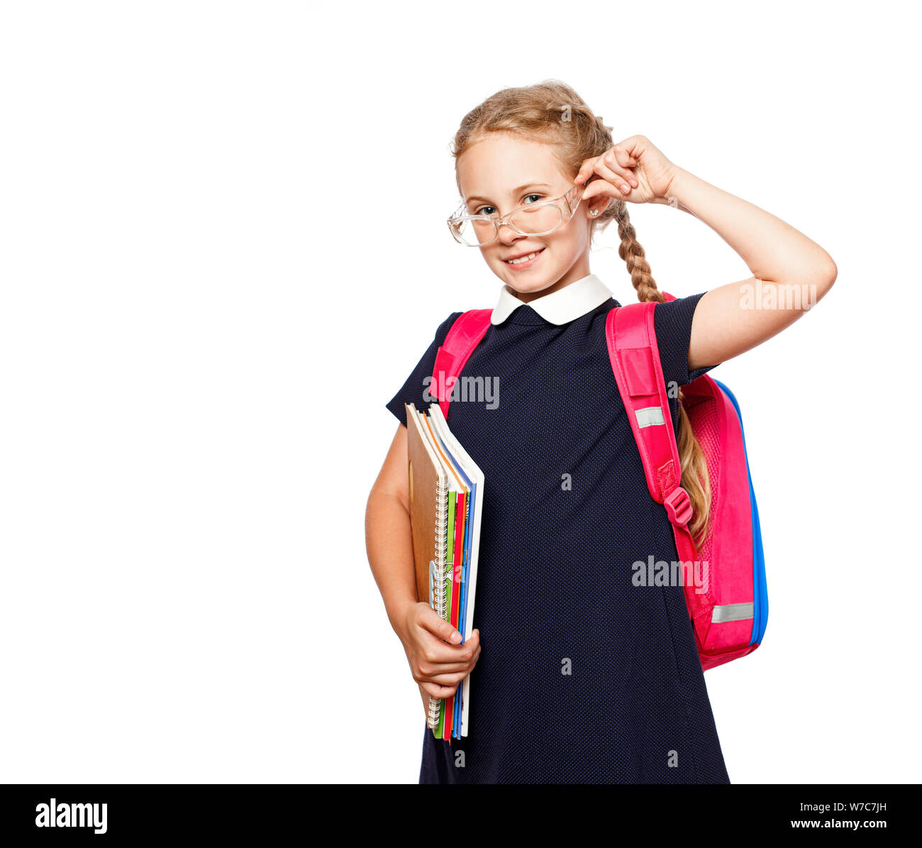 Cheerful 8 years old schoolgirl with backpack wearing uniform standing isolated over white background. Ready for school Stock Photo