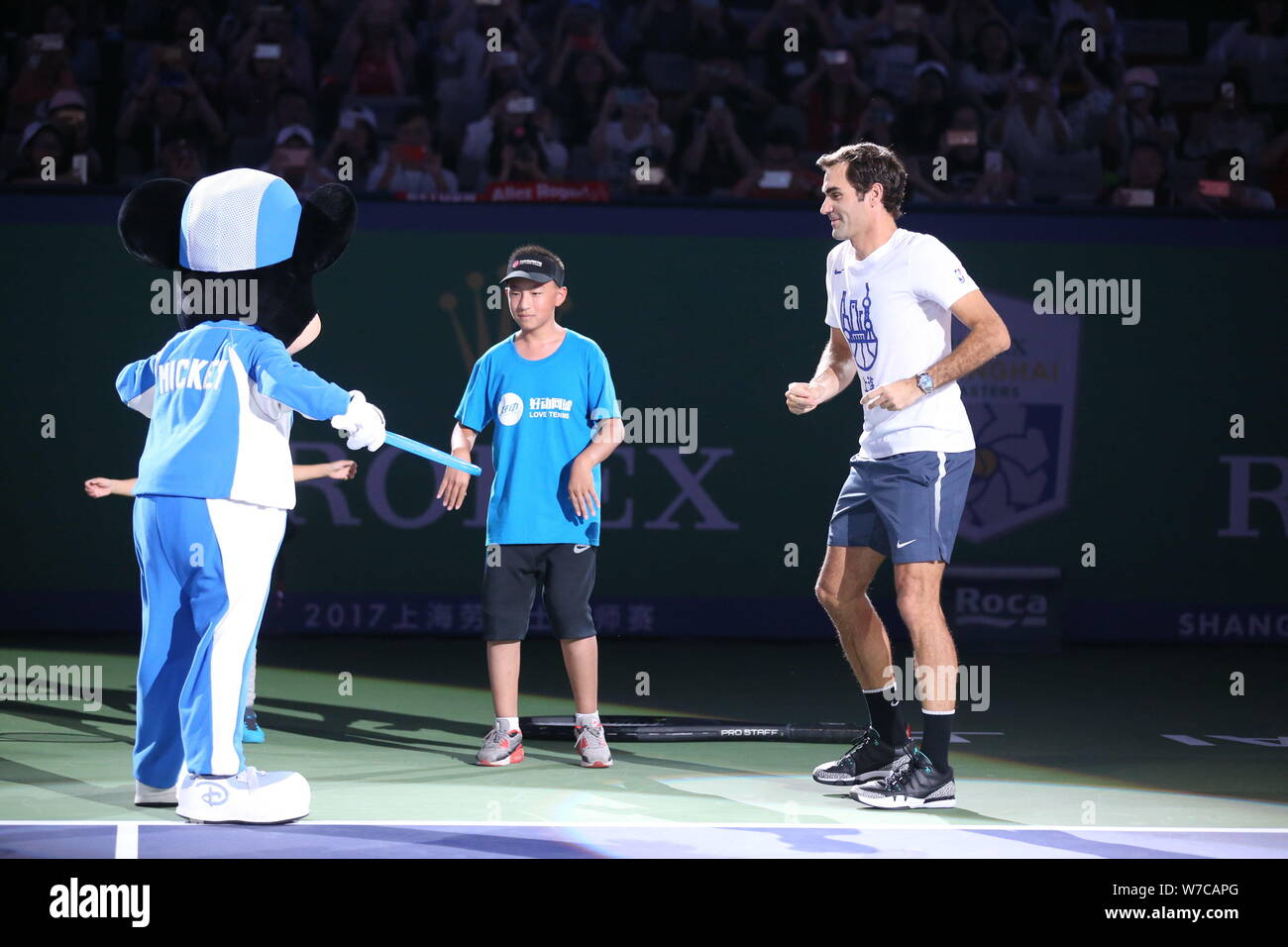 Swiss tennis player Roger Federer enjoys a dance off with Mickey Mouse during Famiy Day of Shanghai Rolex Masters at Qizhong Stadium in Shanghai Chin Stock Photo Alamy