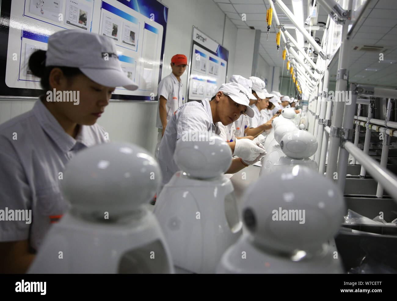 Chinese workers produce robots on the assembly line at China's largest ...