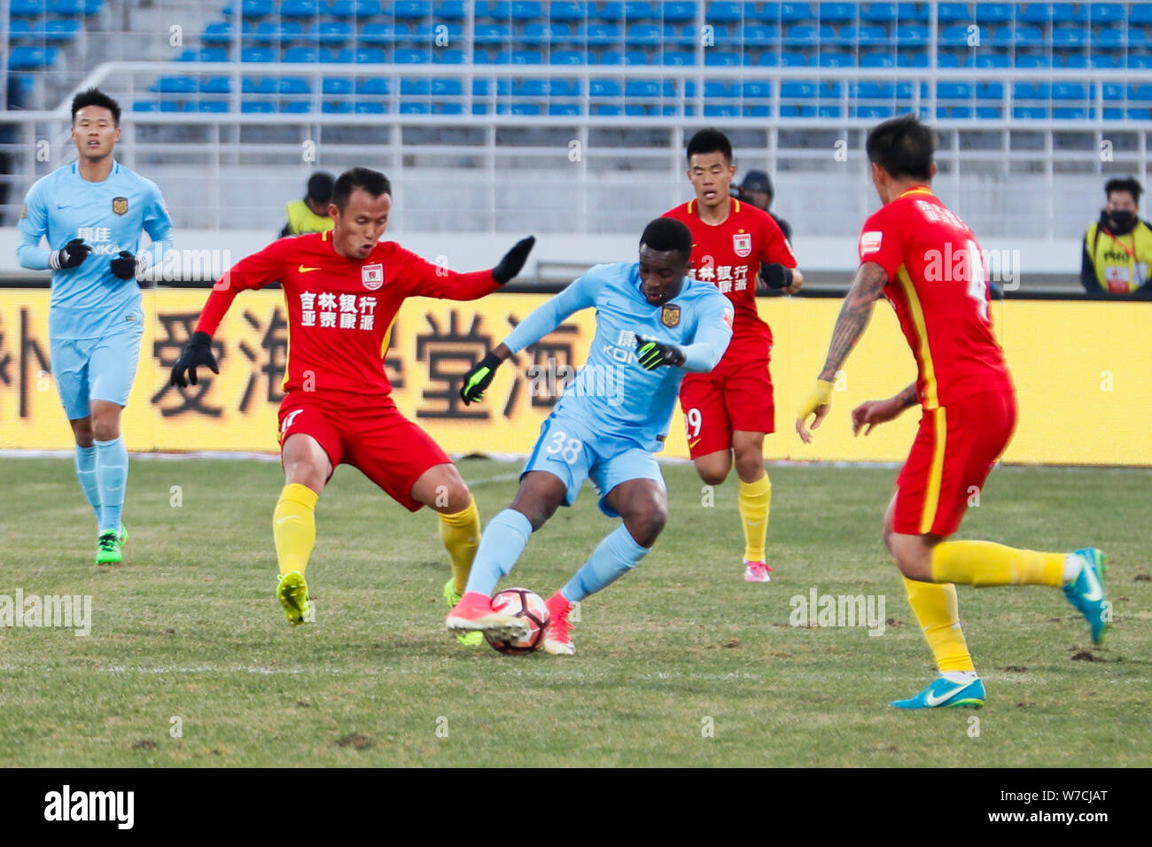 Cameroonian football player Benjamin Moukandjo, center, of Jiangsu Suning kicks the ball to make a pass against players of Changchun Yatai in the 28th Stock Photo