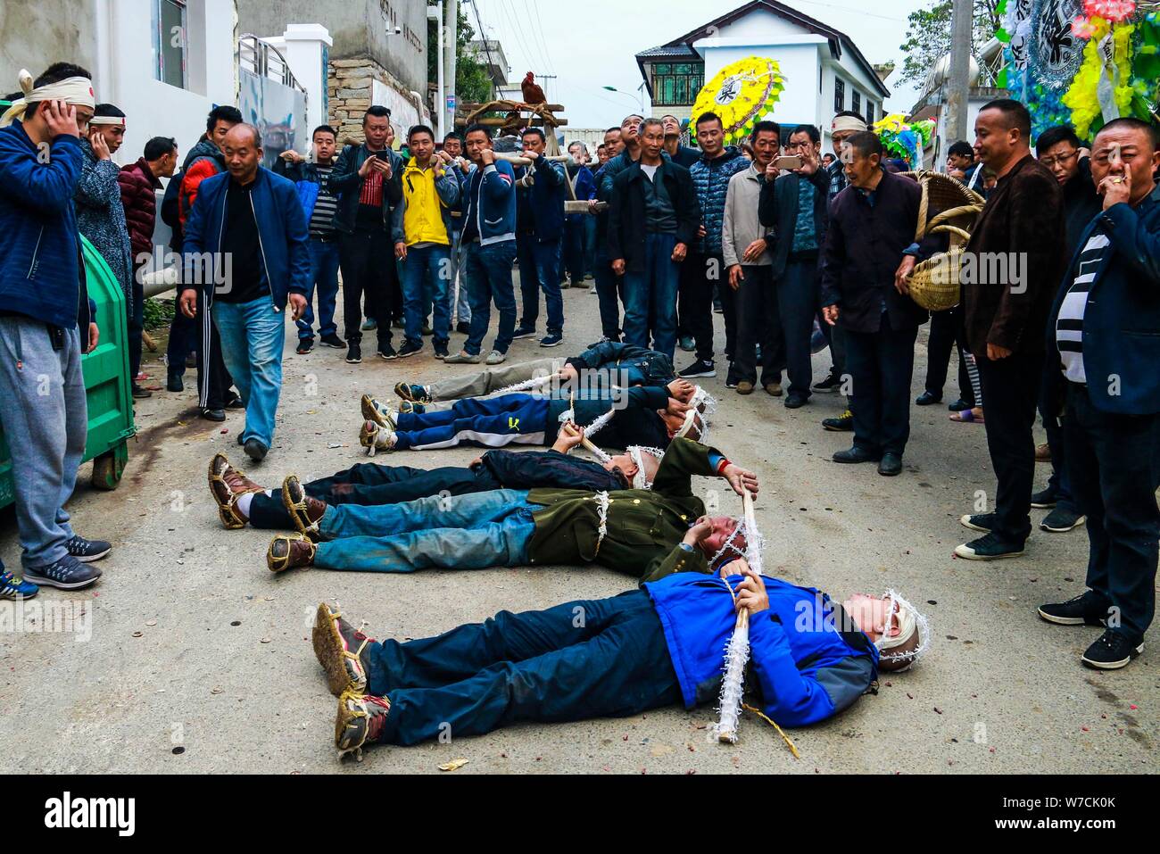 The sons of an elderly woman surnamed Wang who died at 86 years old roll on the ground to express love and devotion to their dead mother during the fu Stock Photo