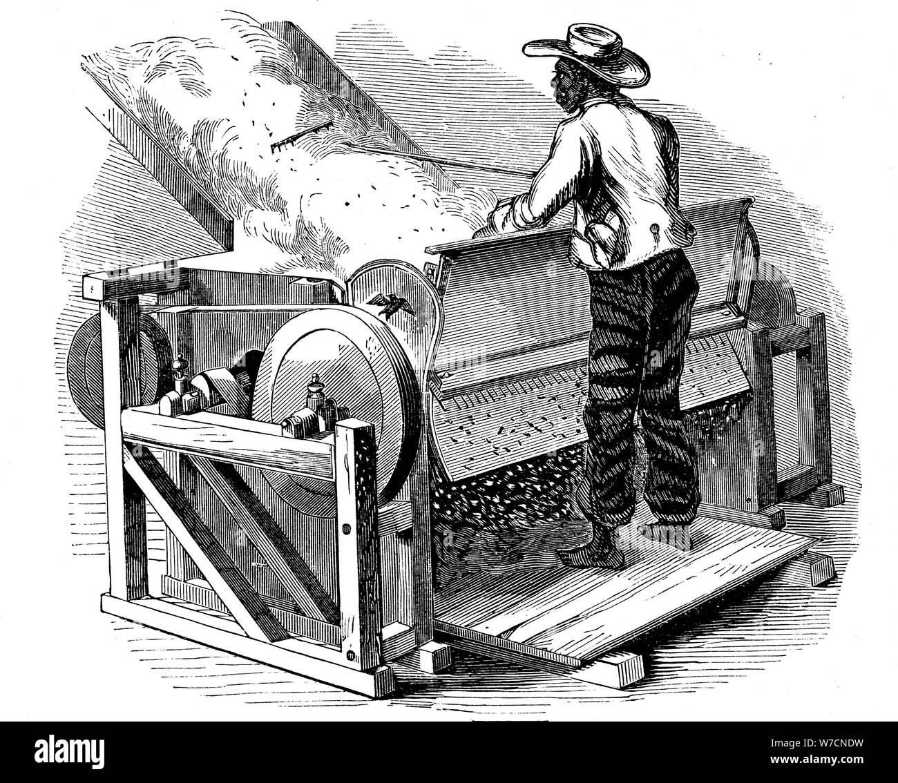 Saw gin for cleaning cotton being operated by barefoot black labourer, southern USA, 1865. Artist: Unknown Stock Photo