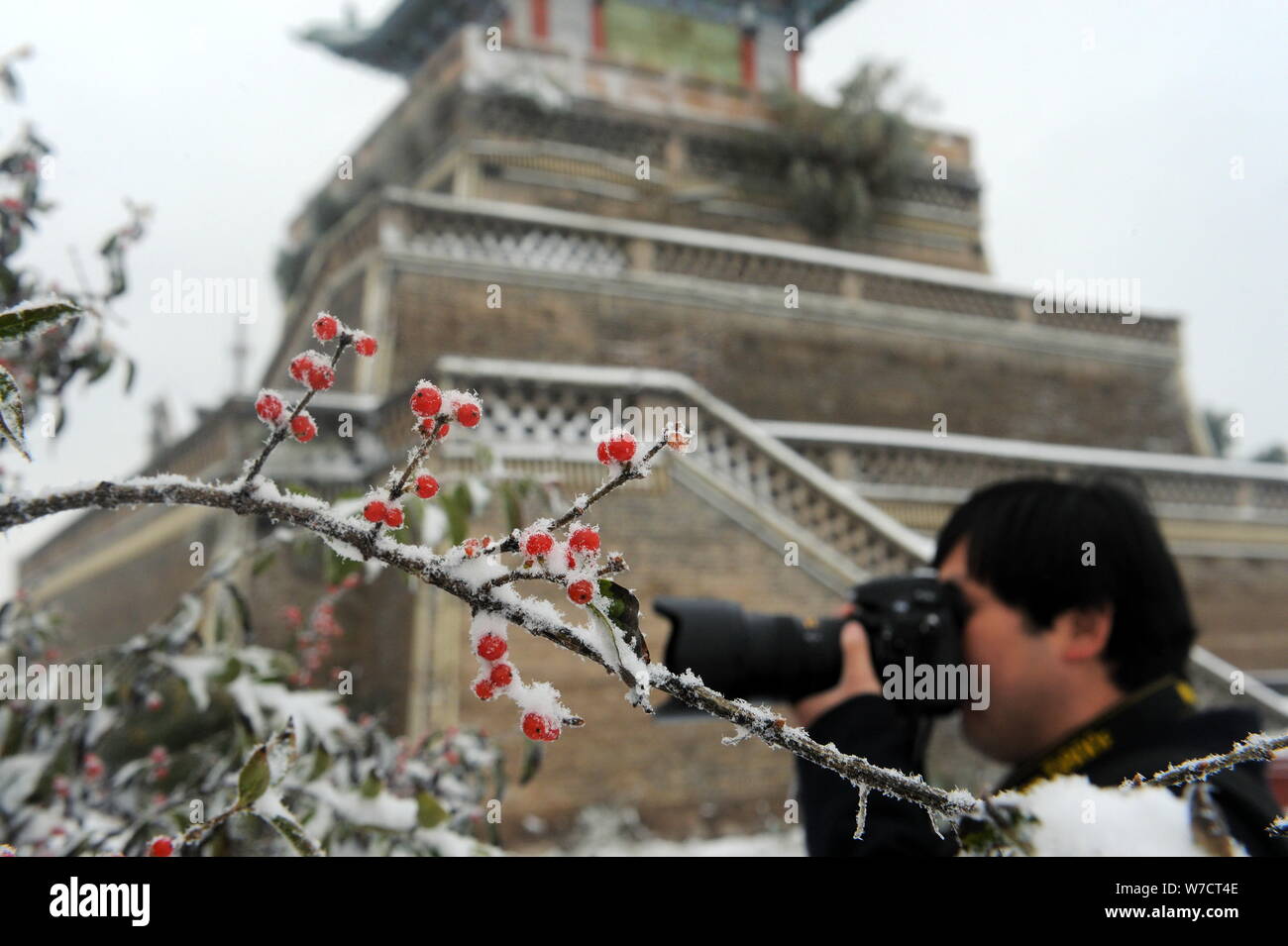 A tourist takes photos beside the Santai Pavilion on Gaolan Mountain after snowfall in Lanzhou city, northwest China's Gansu province, 9 October 2017. Stock Photo