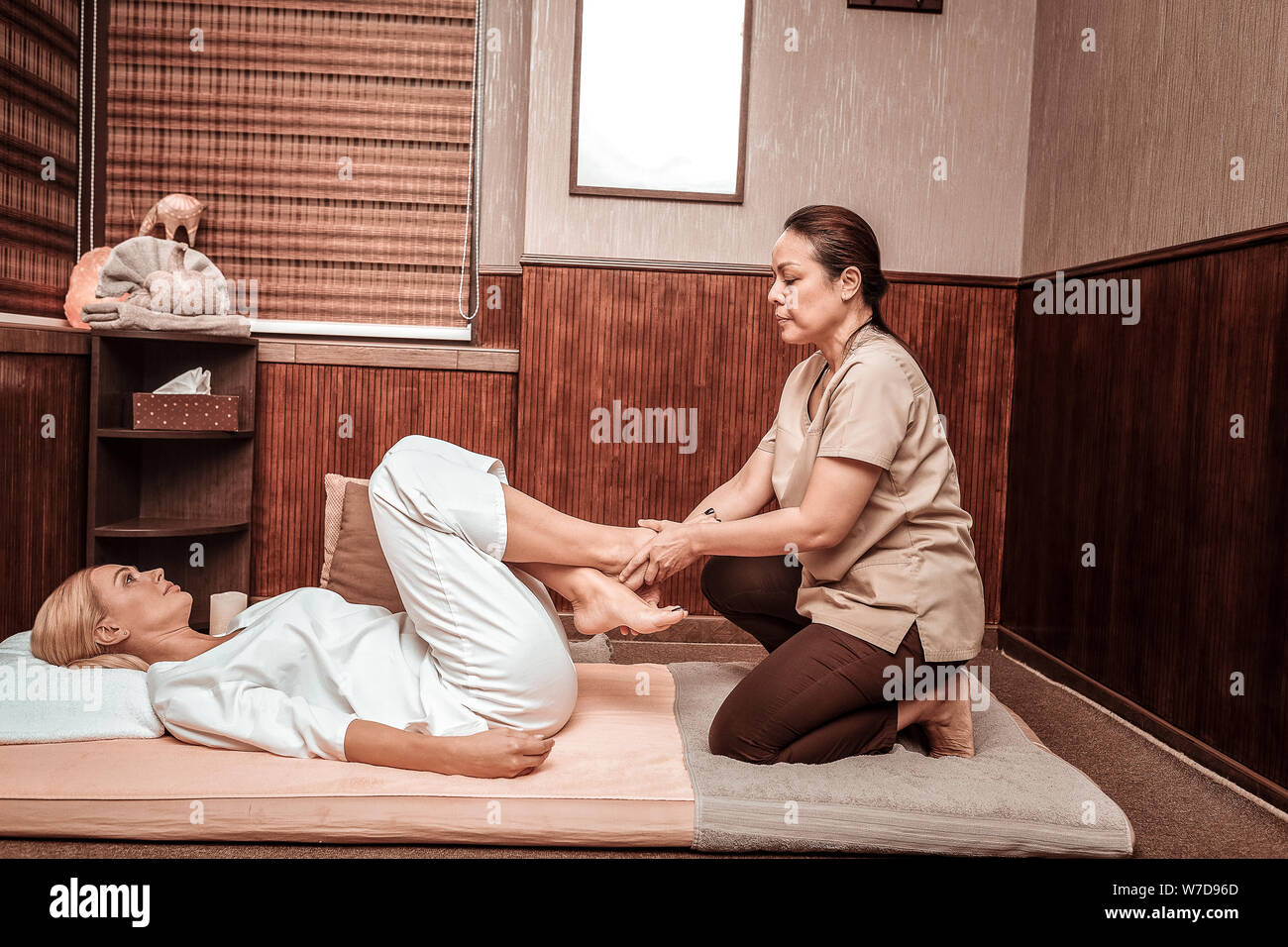 Happy woman having her feet massage in thai massage salon Stock Photo -  Alamy