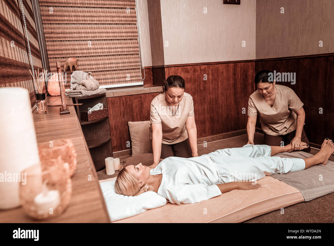 getting four-hand massage in massage salon Stock Photo -