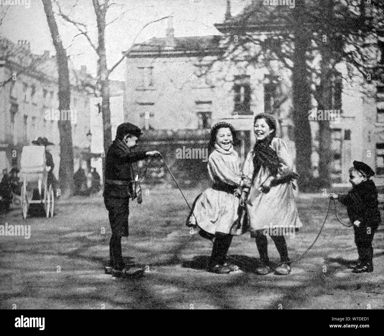 Children skipping in the Grand Place, Bruges, Belgium, 1922.Artist: FC Davis Stock Photo
