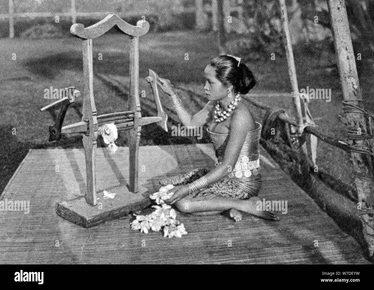 Iban woman making thread with a mangle, Borneo, 1922. Artist: Dr Charles Hose Stock Photo