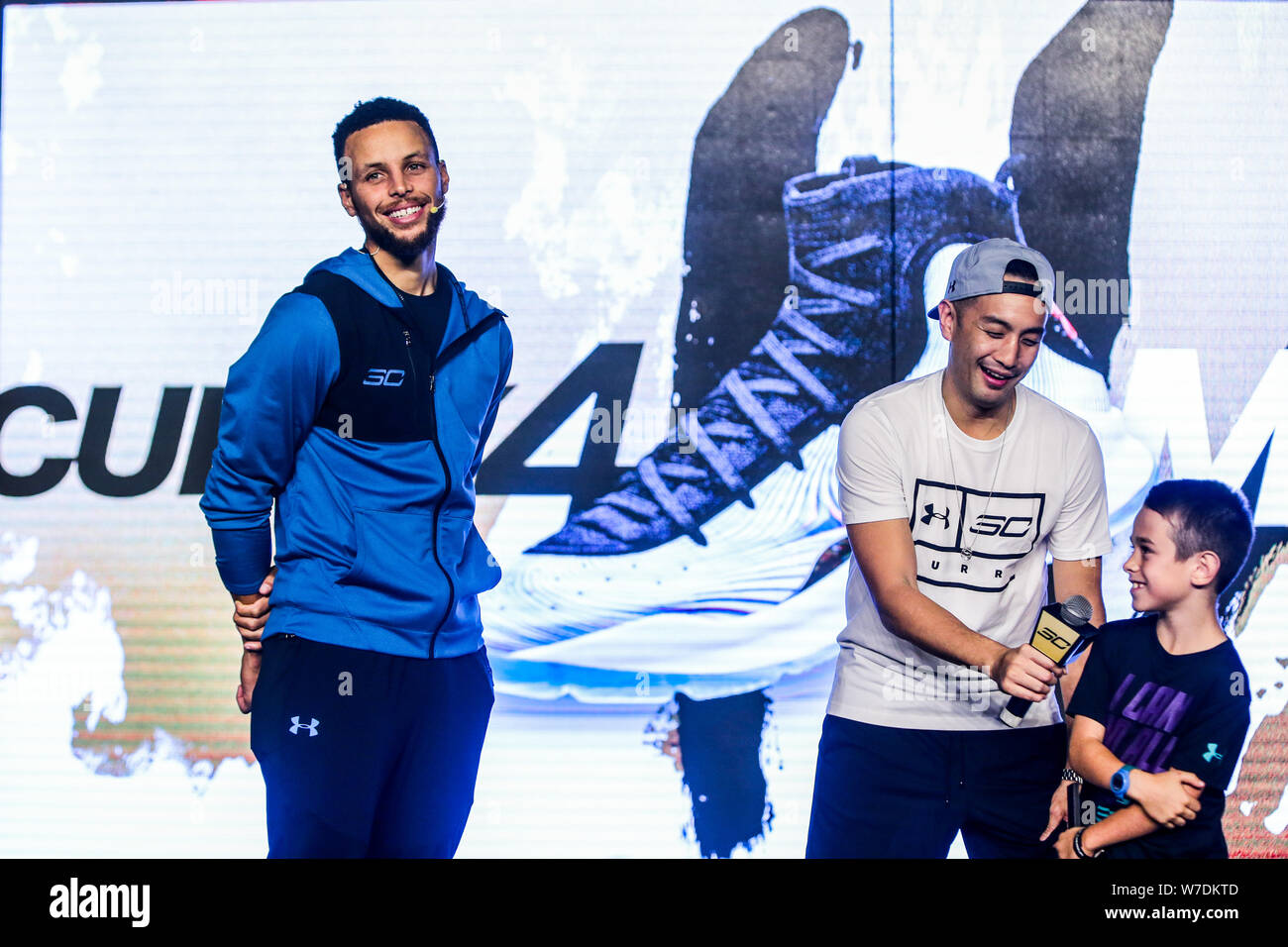 NBA star Stephen Curry of Golden State Warriors left interacts