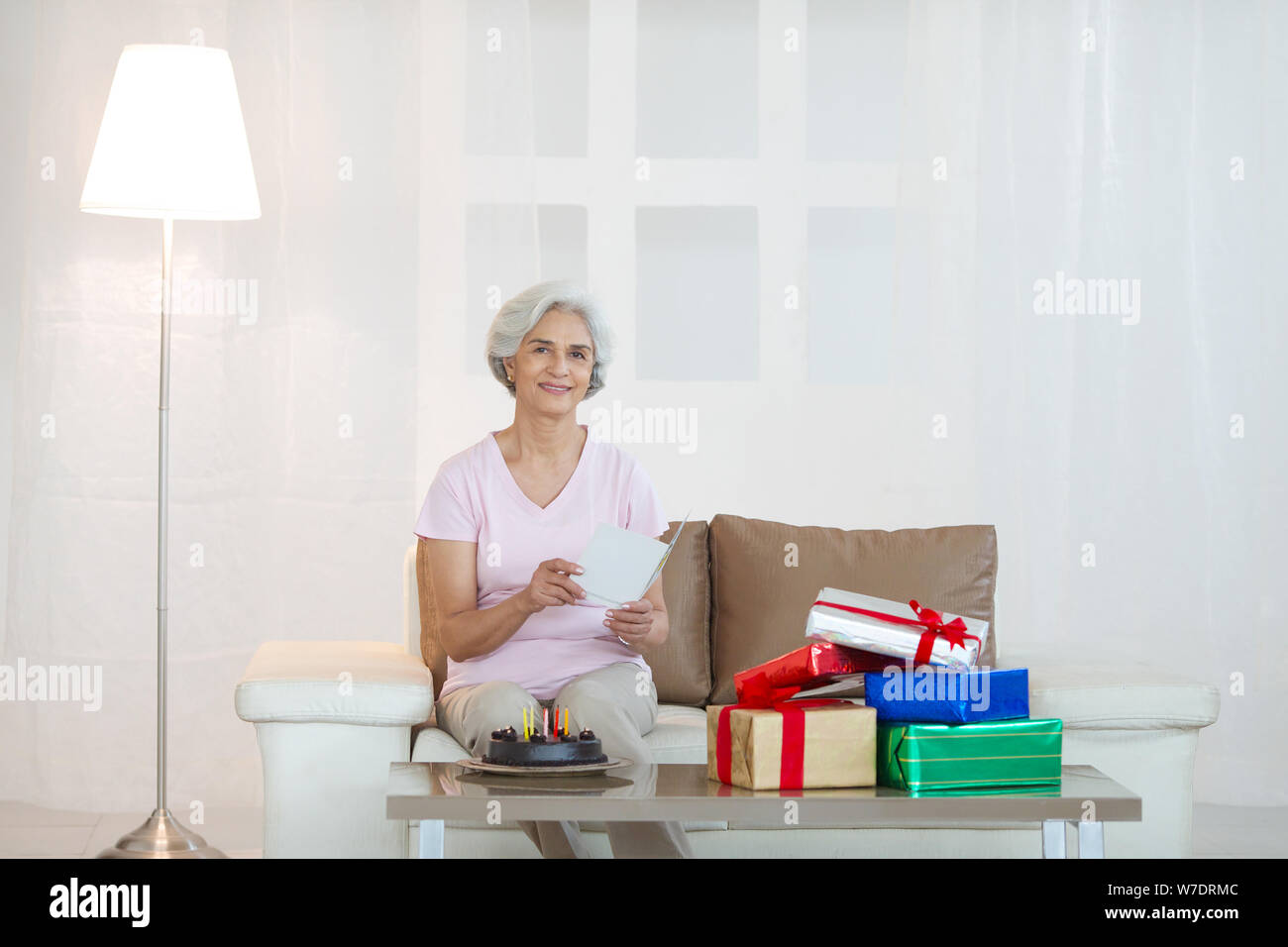 Old woman holding greeting card with birthday cake Stock Photo - Alamy
