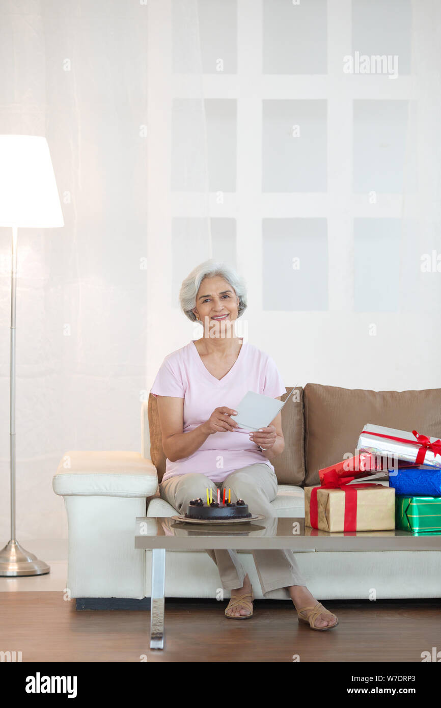 Old woman holding greeting card with birthday cake Stock Photo - Alamy