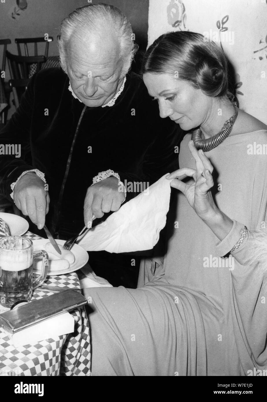 Curd Jürgens showing his wife Simone how to eat Bavarian sausages, Munich, Germany, 1971. Artist: Unknown Stock Photo