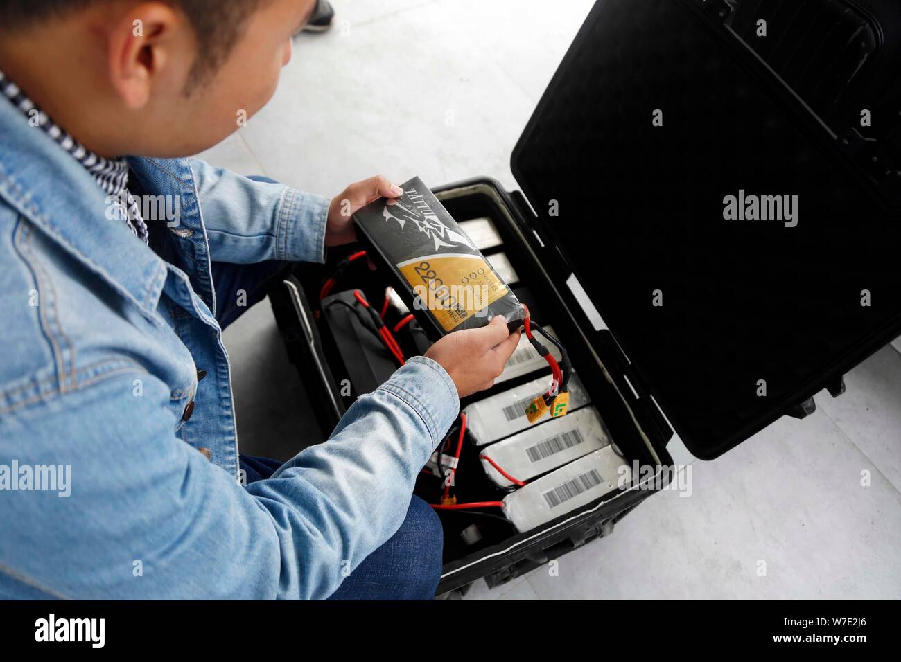 A Chinese enthusiast checks the batteries for drone, or UAV (unmanned aerial vehicle), at the