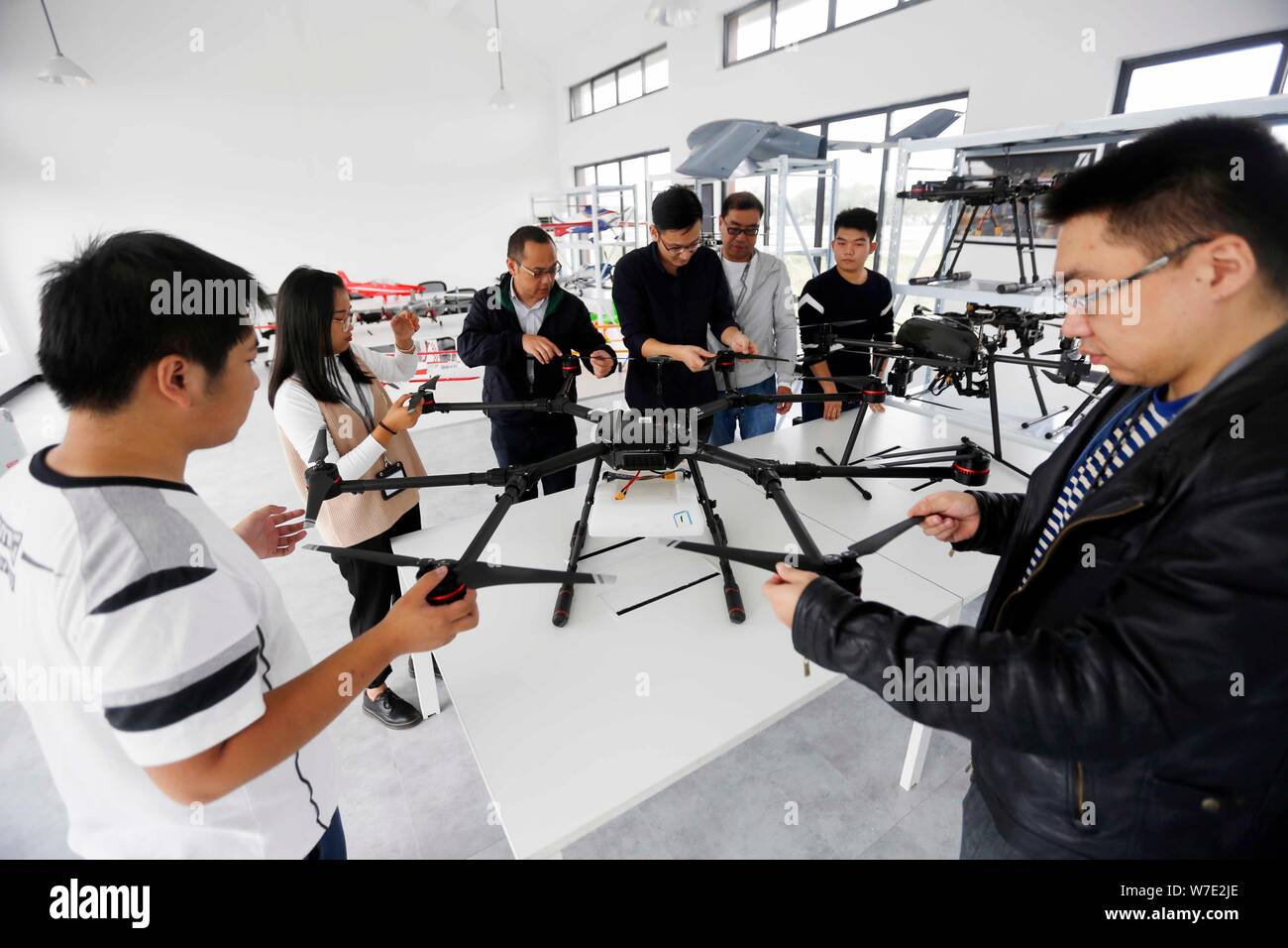 Visitors look at drones, or UAVs (unmanned aerial vehicles), on display at the China's first test-flight base for civilian drones of Civil Aviation Ad Stock Photo